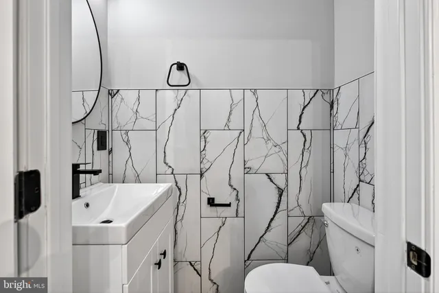 a bathroom with a sink and mirror with toilet