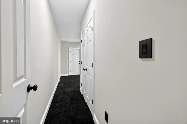 a view of a hallway with a black white wall