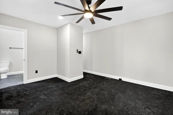 an empty room with closet and fan