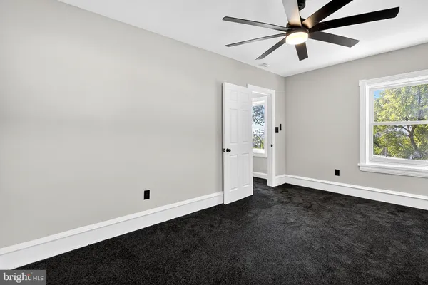 an empty room with a window and a fan