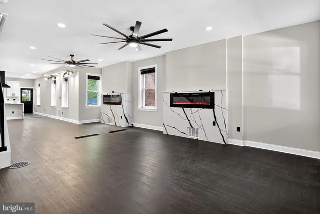 a view of a livingroom with wooden floor and a ceiling fan