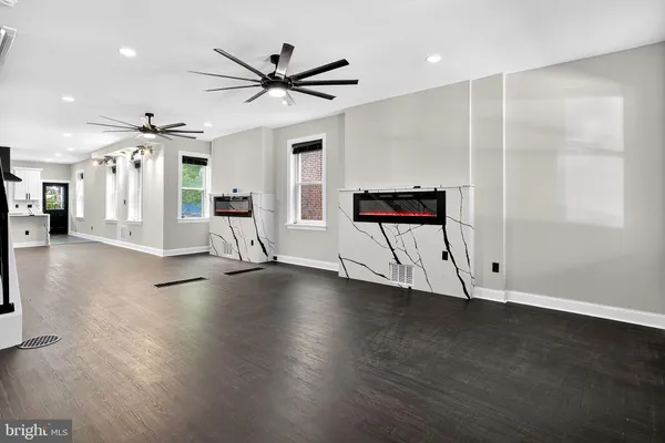 a view of a livingroom with wooden floor and a ceiling fan