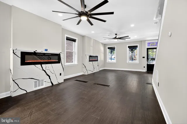 a view of an empty room with window and wooden floor