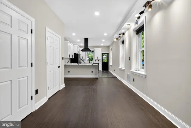 a view of a hallway with cabinet and mirrors
