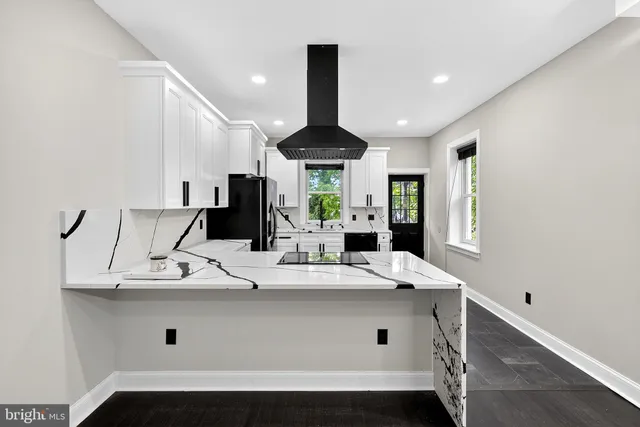 a view of kitchen with granite countertop a sink stainless steel appliances and cabinets