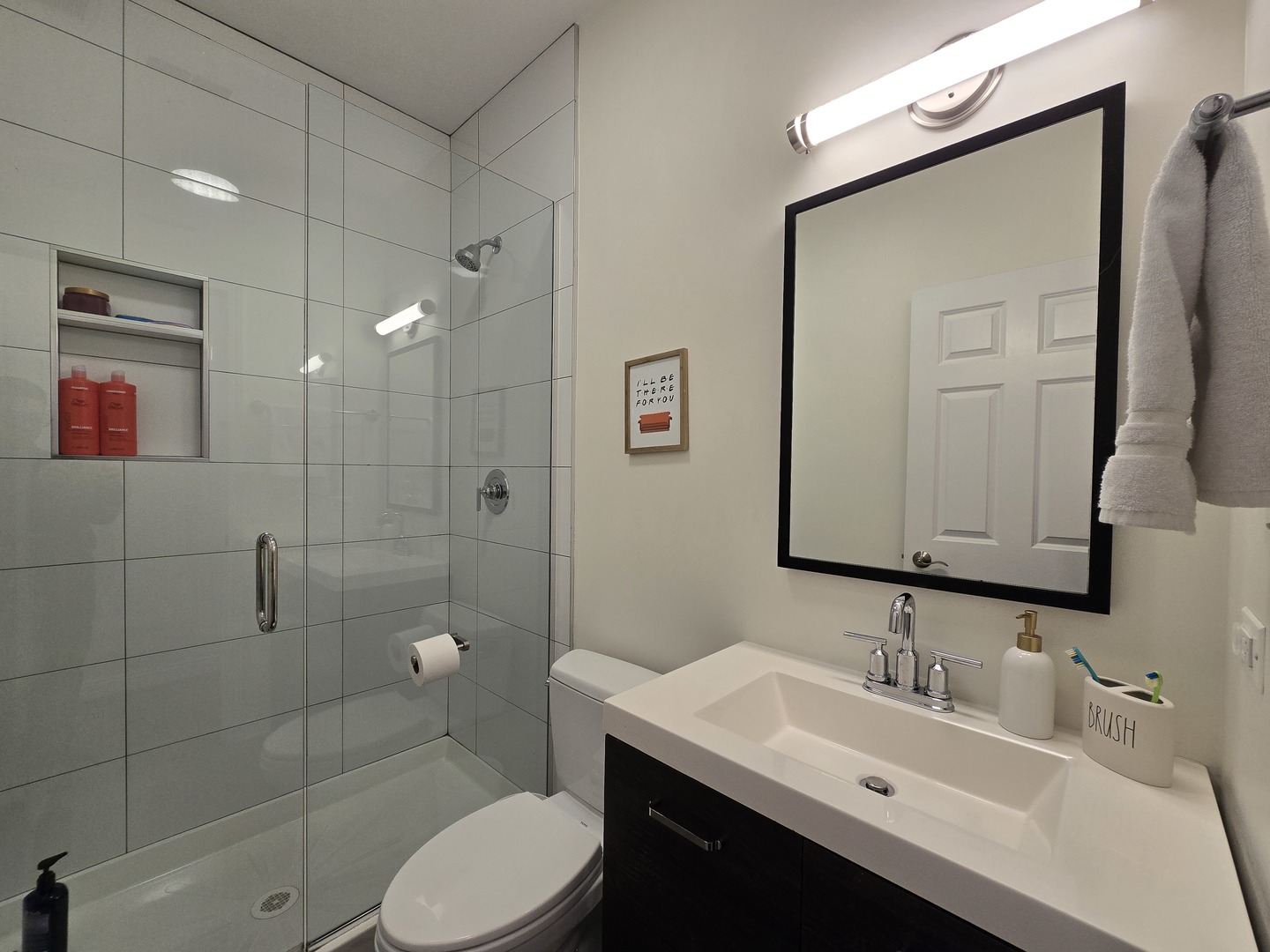 723 West 34th Street, Unit 2E Chicago, IL 60616 - Photo 7 of 9 a bathroom with a toilet a sink a mirror a vanity and shower
