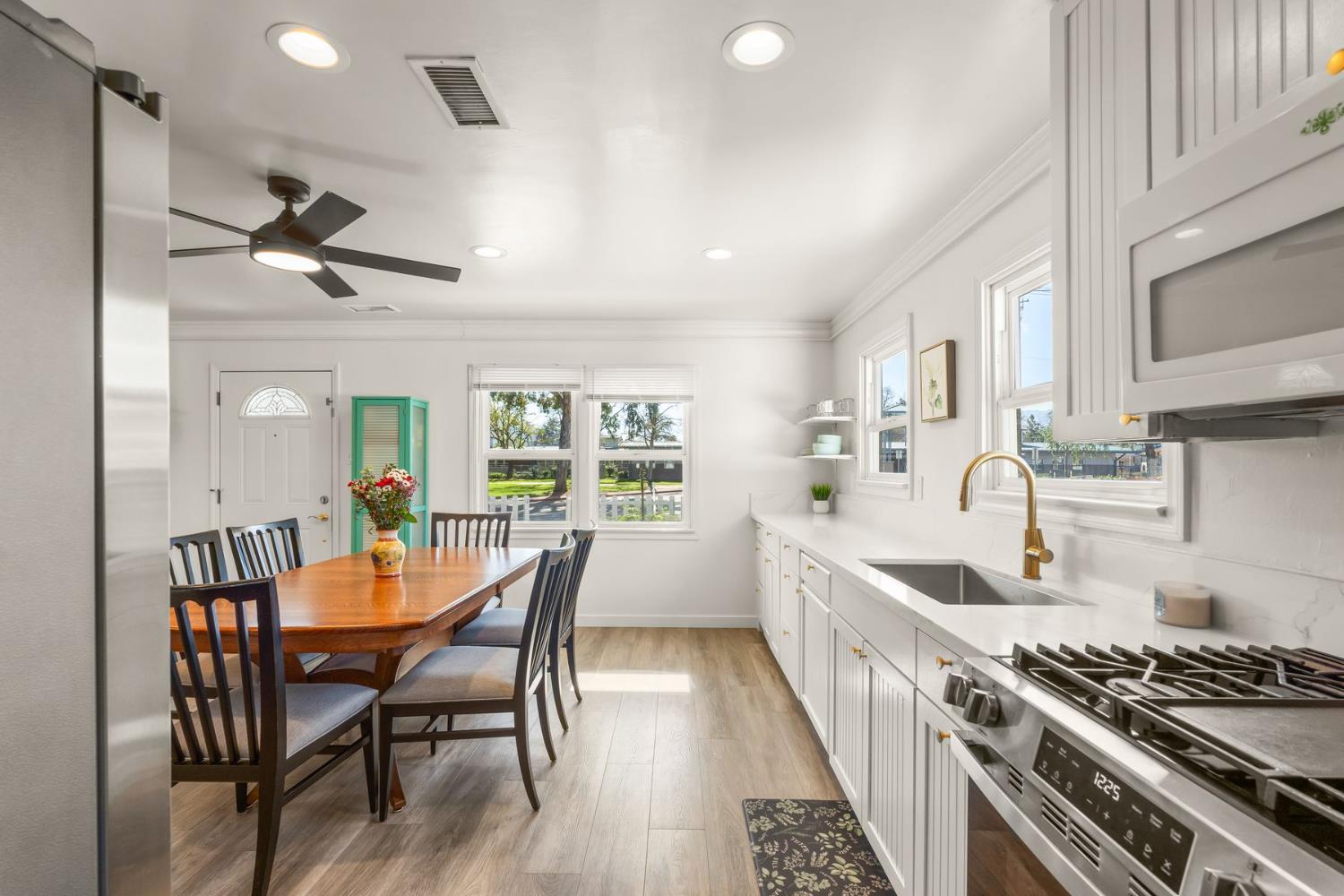 385 Sunset Avenue Oak View, CA 93022 - Photo 9 of 27 a kitchen with stainless steel appliances a dining table chairs stove and white cabinets