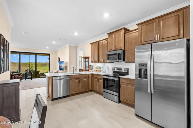 a kitchen with stainless steel appliances granite countertop a refrigerator a stove top oven a sink dishwasher and white cabinets with wooden floor
