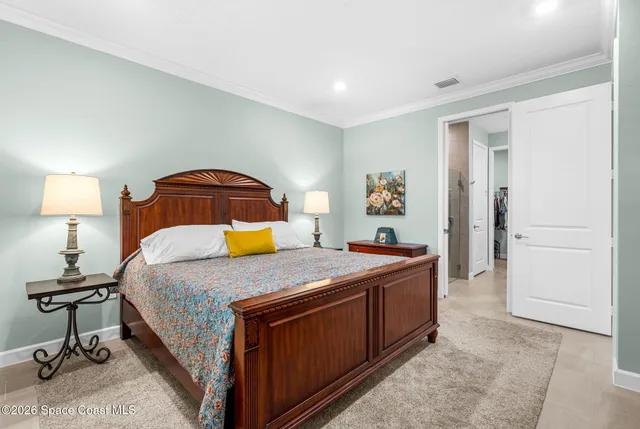 a bedroom with a bed and a lamp on dresser