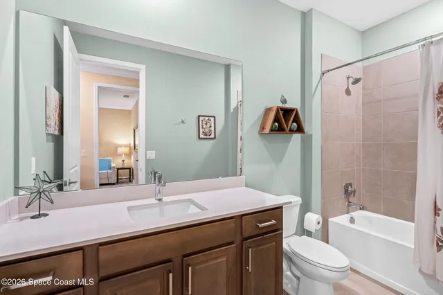 a bathroom with a granite countertop sink toilet a mirror a vanity and shower