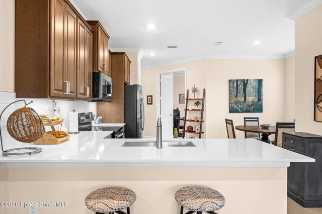a kitchen with stainless steel appliances granite countertop a sink and a refrigerator
