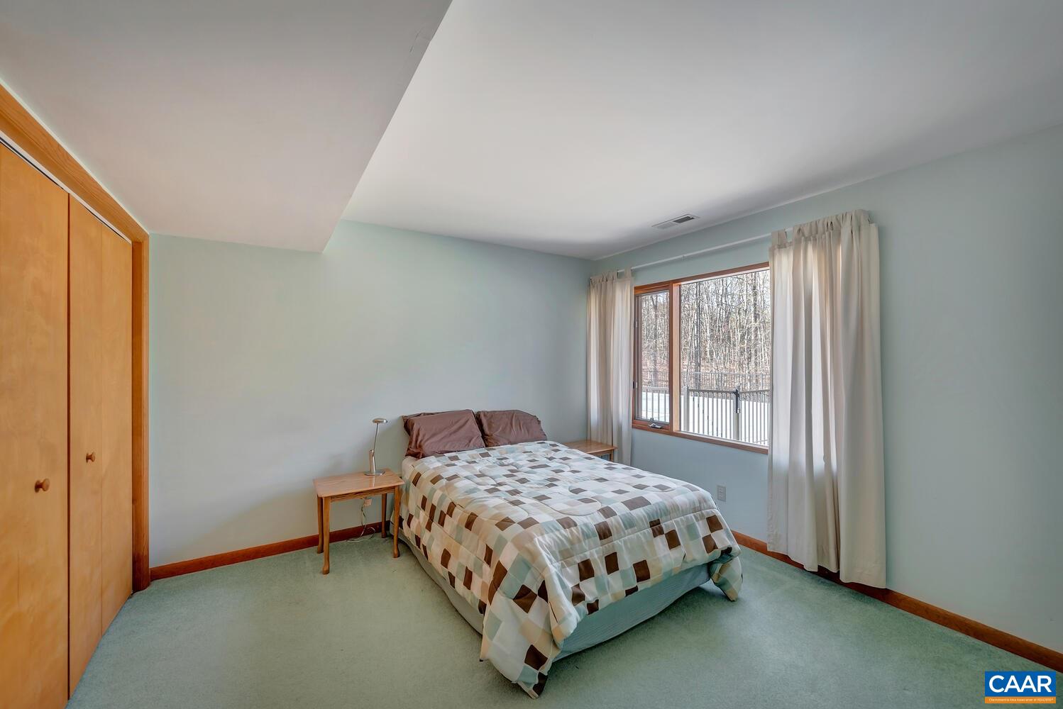 2706 Paddock Wood Road Keswick, VA 22947 - Photo 28 of 42 a bedroom with a bed lamp and window