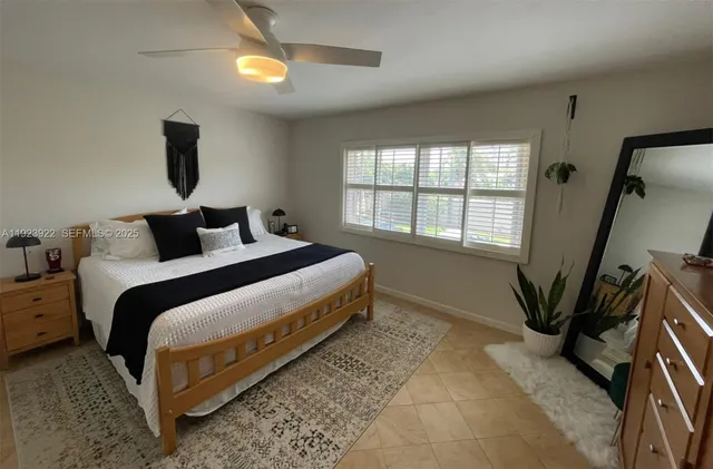 a bedroom with a bed a chandelier and a window