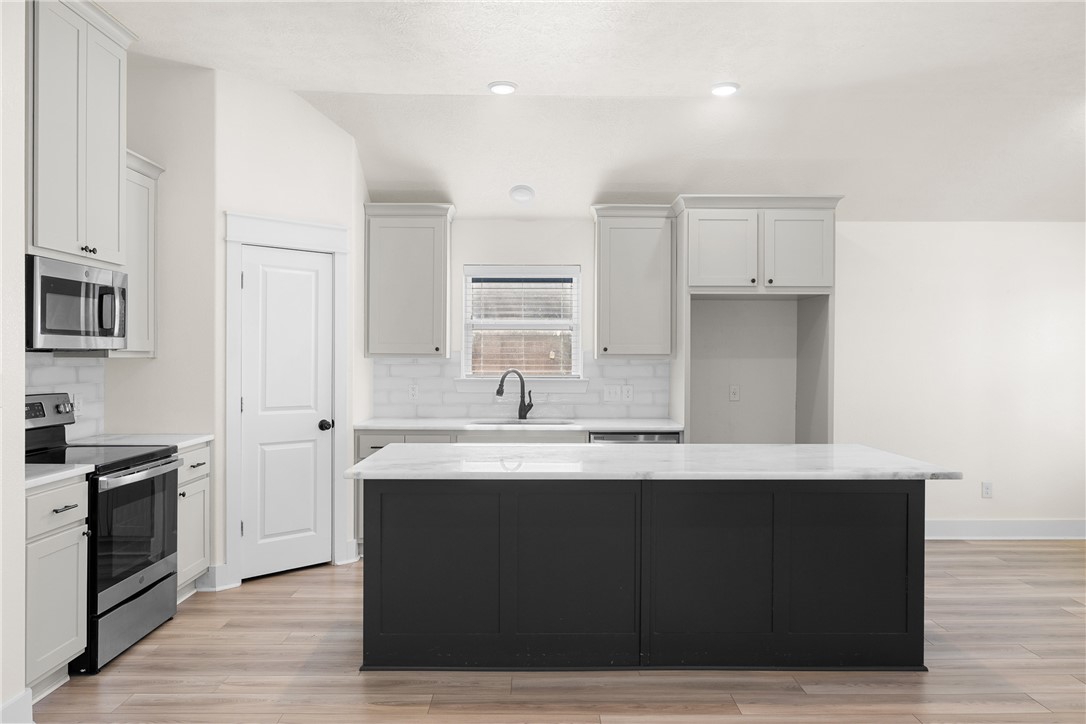 172 Pleasant Path Somerville, TX 77879 - Photo 3 of 13 a kitchen with stainless steel appliances granite countertop a sink a stove a refrigerator and white cabinets