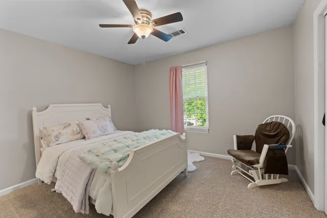 a bedroom with a bed a chair and a window