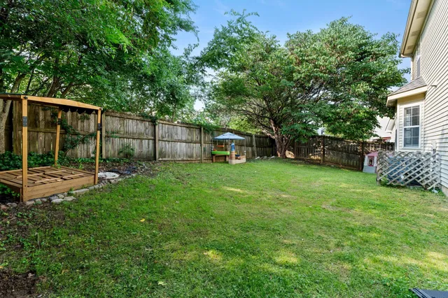 a view of a backyard with a garden and entertaining space