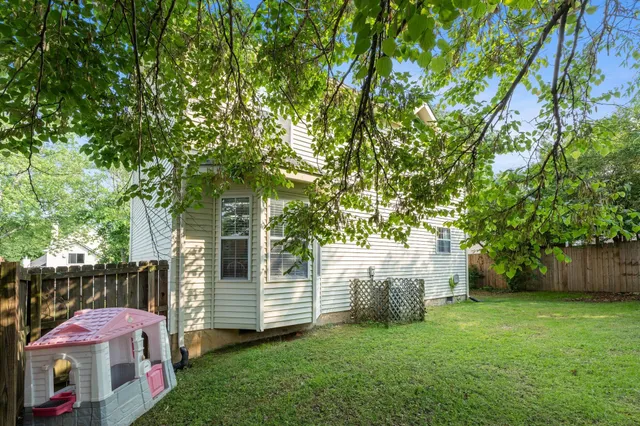 a patio with table and chairs and a large tree