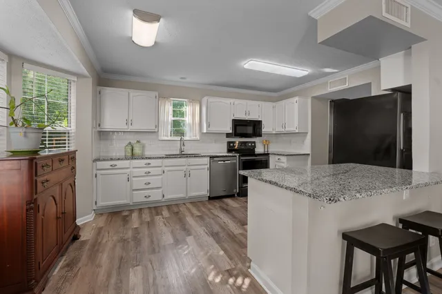 a kitchen with a microwave stove top oven and sink