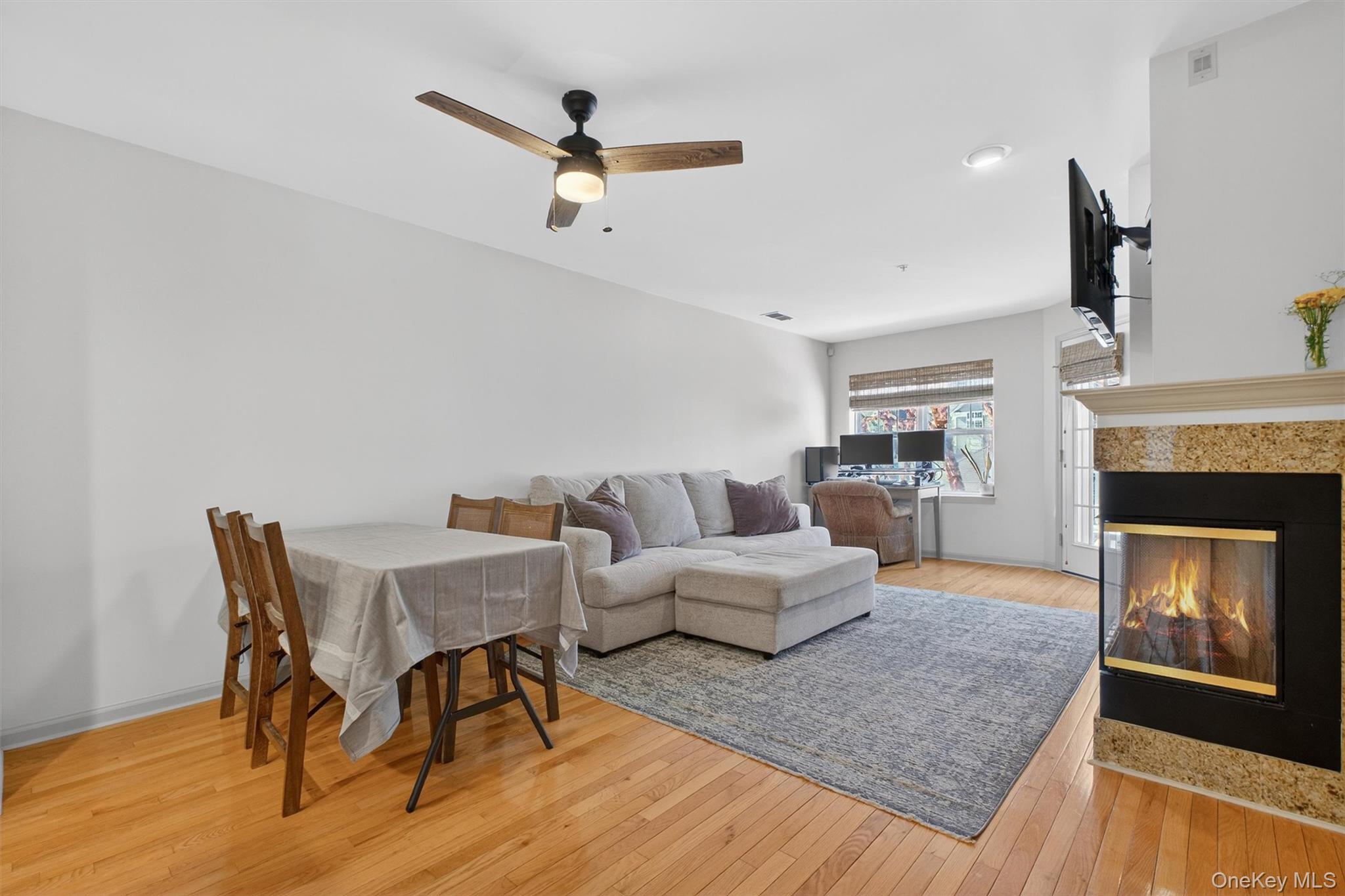 213 Riverbend Drive Peekskill, NY 10566 - Photo 5 of 46 Living Room and Dining Area with ceiling fan, cozy fireplace and hardwood floors.