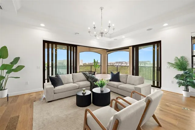 a kitchen with stainless steel appliances kitchen island granite countertop a stove a refrigerator a sink a dining table and chairs with wooden floor