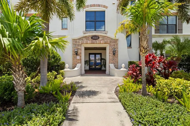 a living room with furniture large window and wooden floor