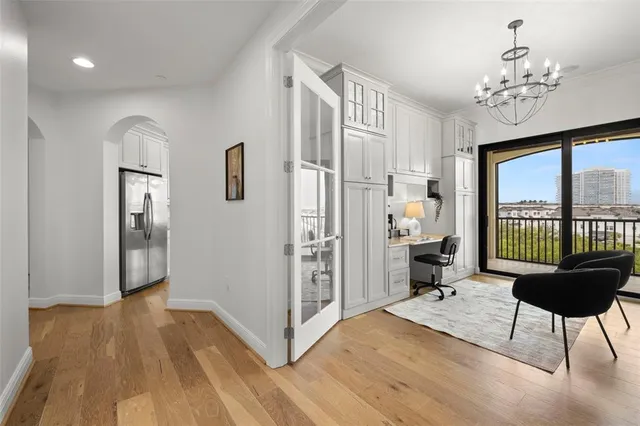 an empty room with windows and chandelier fan