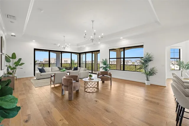 a living room with furniture kitchen view and a chandelier