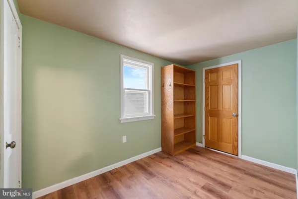 an empty room with closet and windows