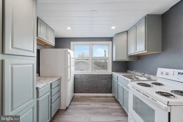 a kitchen with a refrigerator a stove top oven a sink and dishwasher