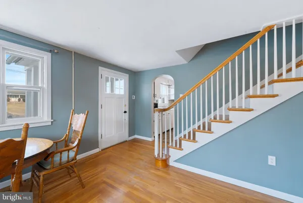a view of a hallway with an entryway and wooden floor