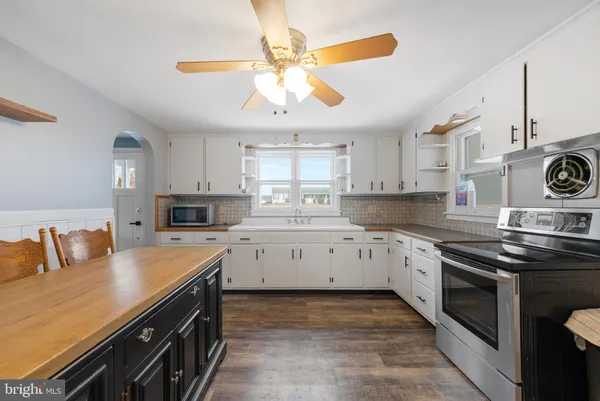 a kitchen with stainless steel appliances granite countertop a sink a stove and a refrigerator