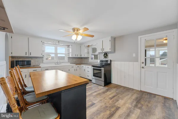 a kitchen with a table chairs sink and cabinets