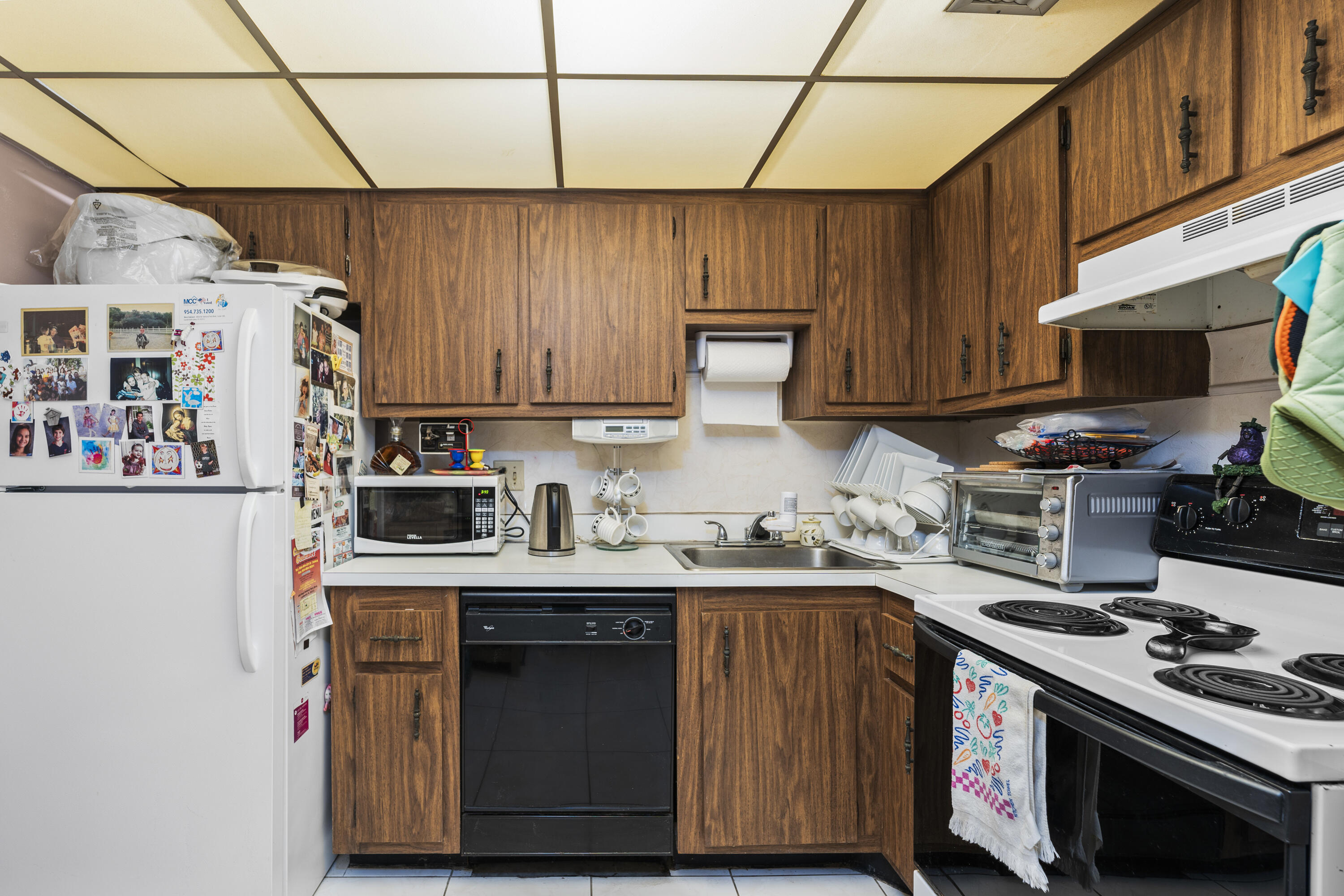4174 Inverrary Drive, Unit 413 Lauderhill, FL 33319 - Photo 8 of 20 a kitchen with stainless steel appliances a stove a sink a refrigerator and wooden cabinets