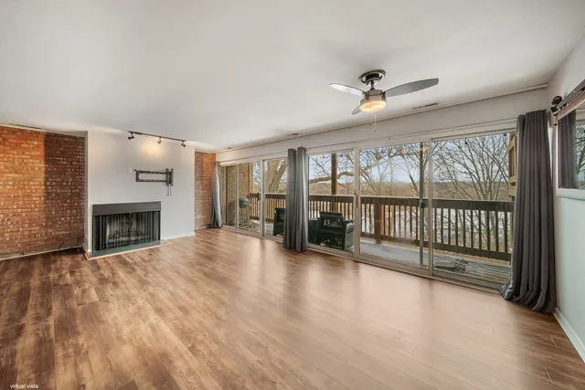 wooden floor fireplace and windows in an empty room