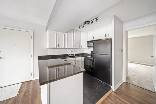 a kitchen with granite countertop a refrigerator and a sink