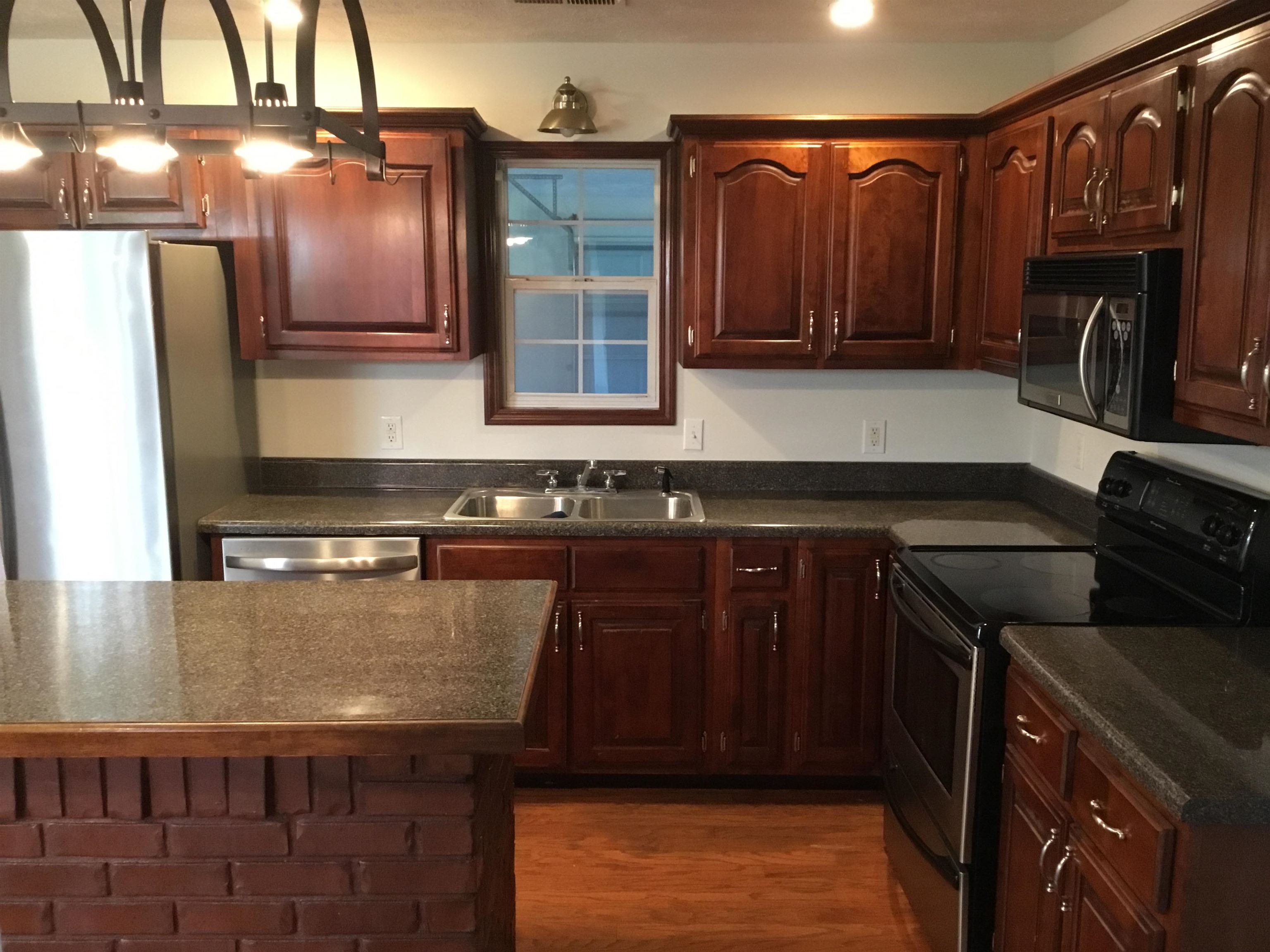 2695 Central Curve Road Ripley, TN 38063 - Photo 12 of 32 a kitchen with granite countertop stainless steel appliances and wooden cabinets