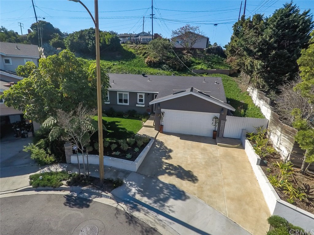 a view of a house with a yard and potted plants