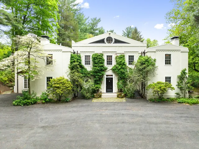 a front view of a house with a garden