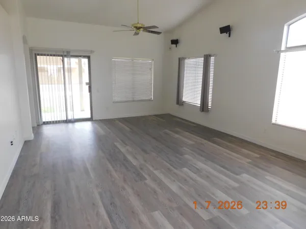 an empty room with wooden floor and windows