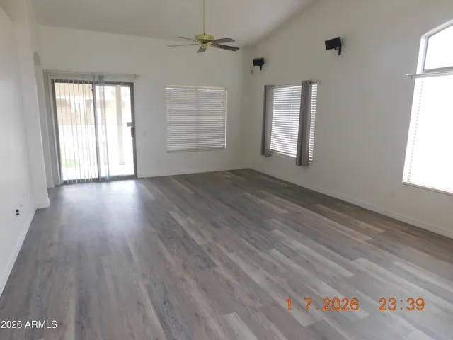 an empty room with wooden floor and windows