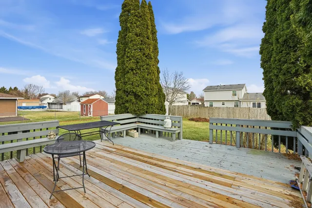 a view of backyard of house with wooden fence