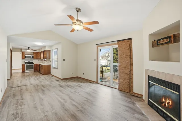 a view of an empty room with a fireplace and a window