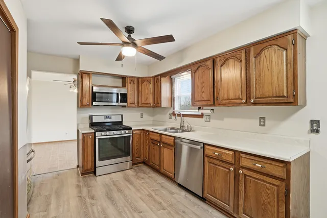 a kitchen with stainless steel appliances granite countertop a sink a stove top oven a refrigerator with island and chairs