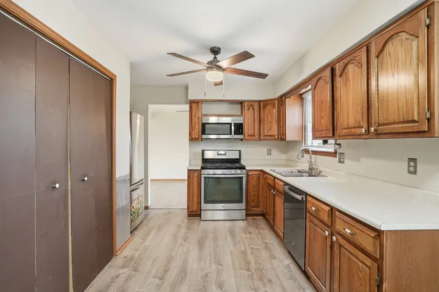 a kitchen with stainless steel appliances granite countertop a refrigerator a sink dishwasher a stove with wooden cabinets and a refrigerator