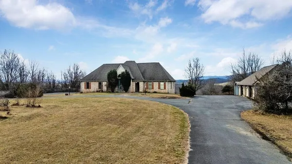 a view of a house with a yard and sitting area