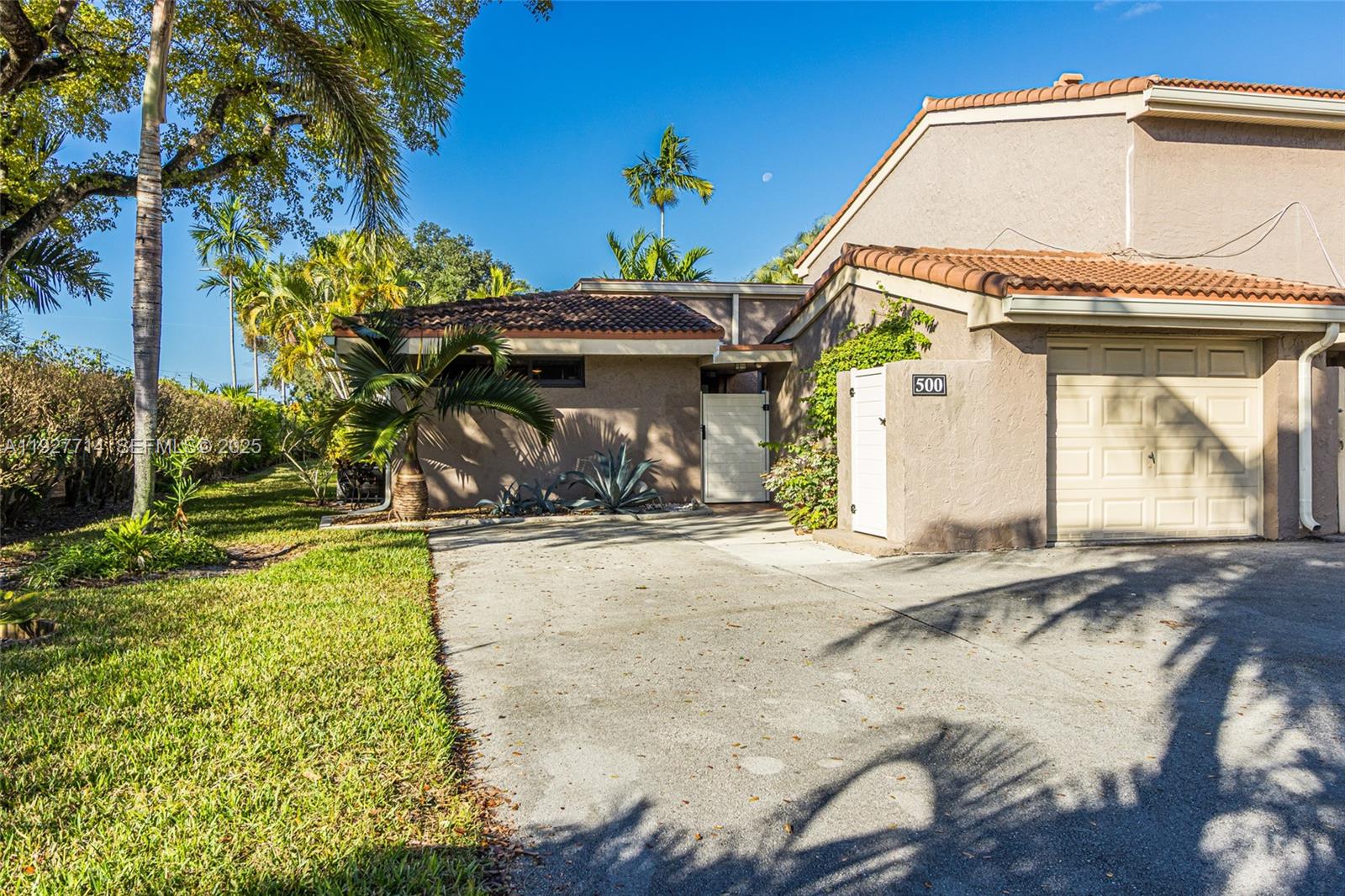500 Bonnie Brae Way, Unit 17 Hollywood, FL 33021 - Photo 20 of 32 a view of a white house with large trees and wooden fence