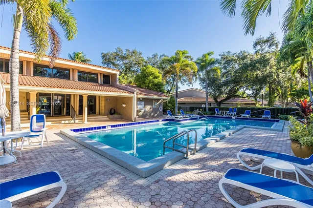 a view of a house with backyard swimming pool and sitting area
