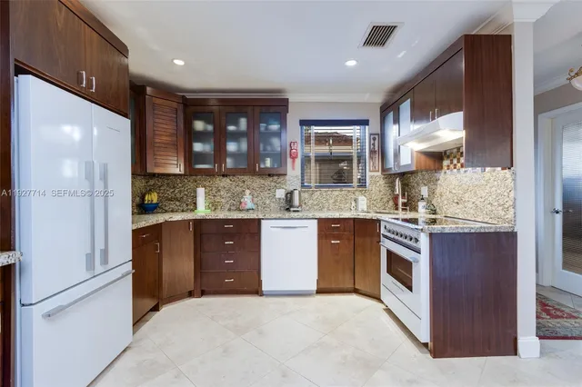 a kitchen with stainless steel appliances granite countertop a refrigerator and a stove