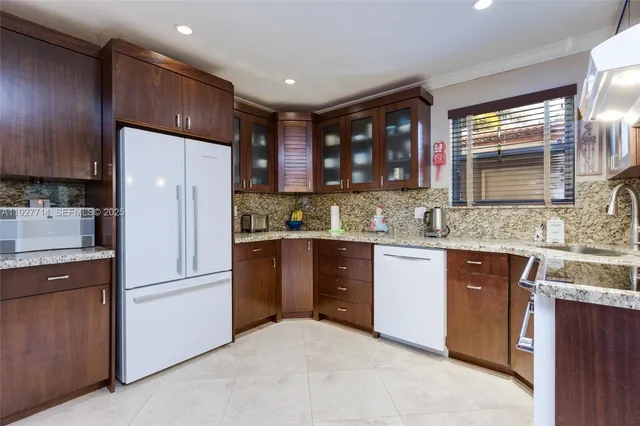 a kitchen with stainless steel appliances granite countertop a refrigerator stove a sink and a granite counter tops