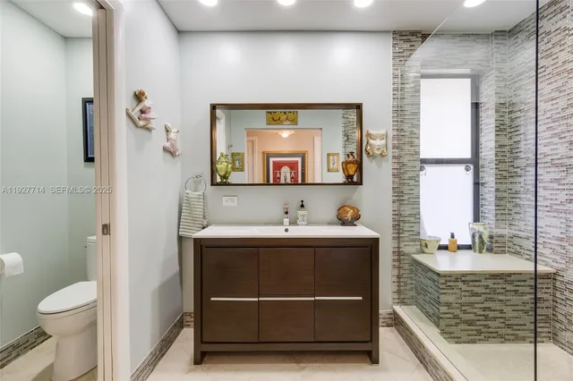 a bathroom with a sink a toilet and a mirror